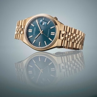 Montre Citizen dorée avec cadran bleu et reflet sur une surface.