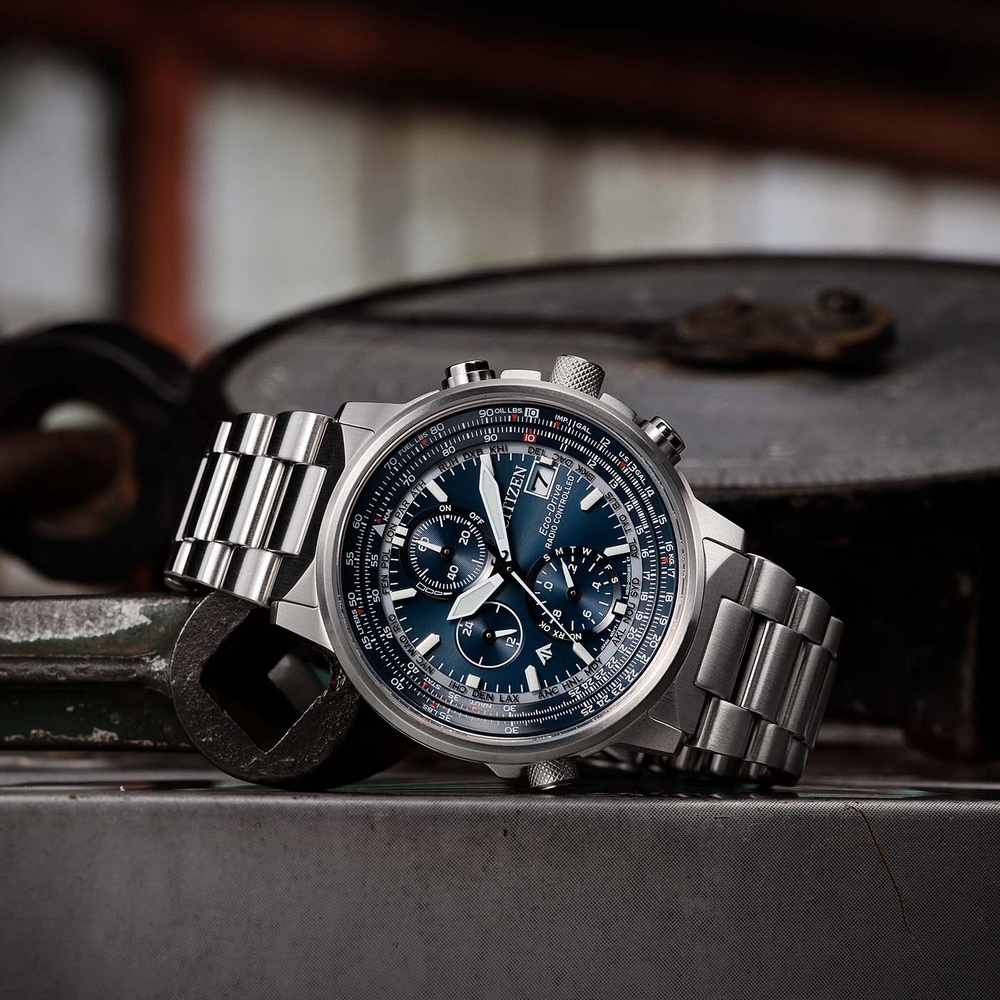 Montre Citizen avec cadran bleu et bracelet en métal sur surface métallique.