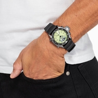 Homme portant une montre, main dans la poche, jean noir, chemise blanche.