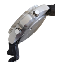 Gros plan d'une montre argentée avec bracelet noir et boutons, vue latérale.