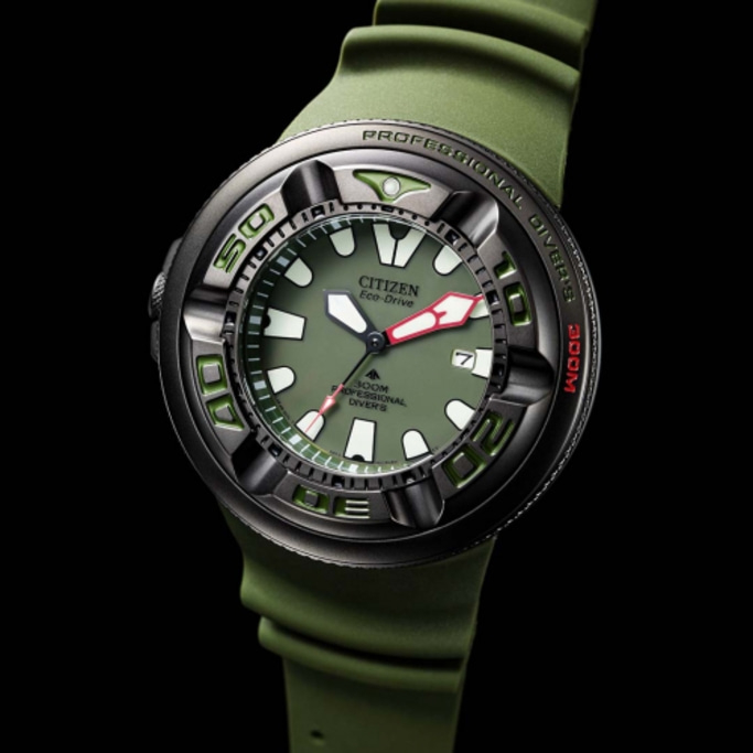 Montre Citizen Eco-Drive avec bracelet et cadran verts, fond noir, gros plan.