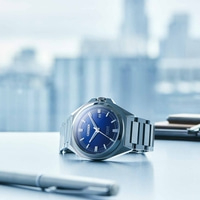 Montre Citizen Series 8 avec cadran bleu sur un bureau avec un stylo.
