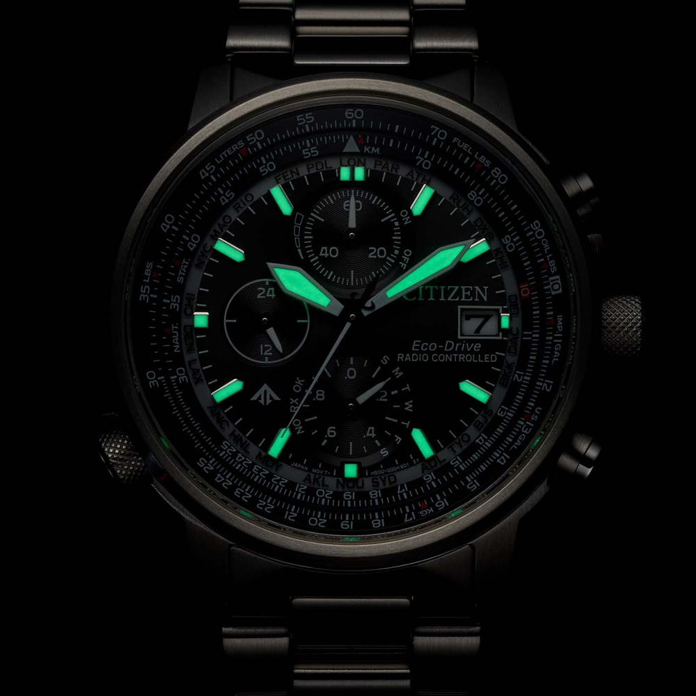 Gros plan d'une montre Citizen avec des accents verts lumineux et des détails complexes.