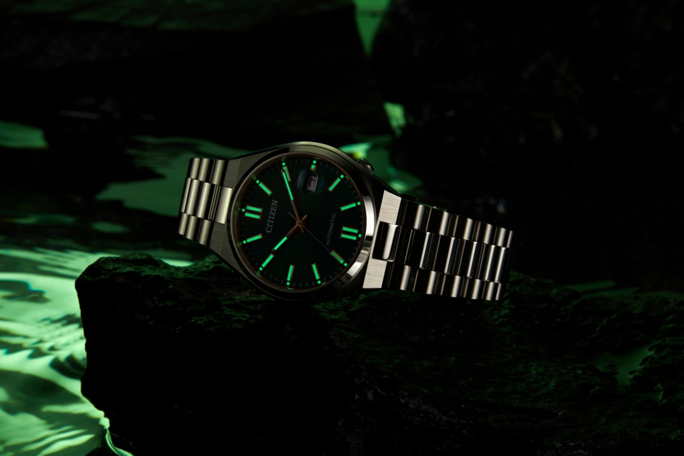 Montre Citizen avec aiguilles et marqueurs lumineux sur fond sombre.